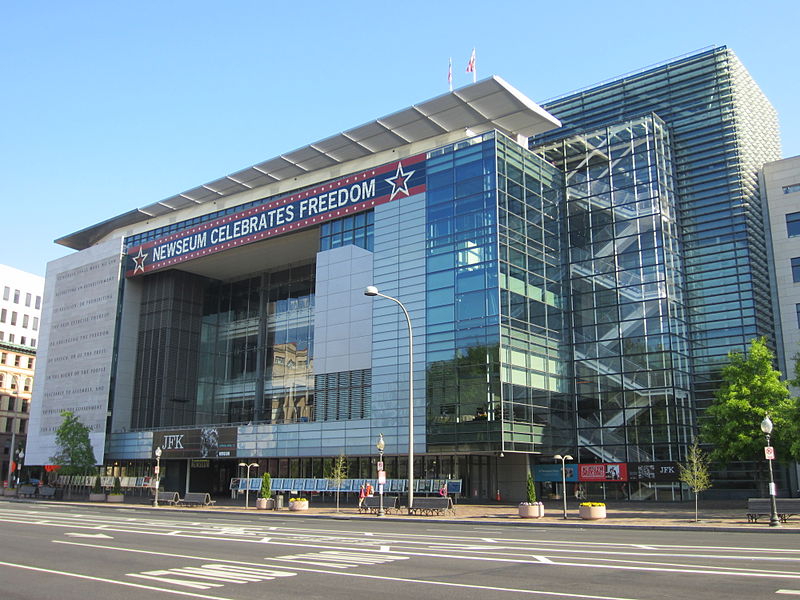 The Newseum resides on Pennsylvania Avenue in Washington DC. The building is seven stories high and its front is mostly of windows. A large banner reads "Newseum celebrates freedom."